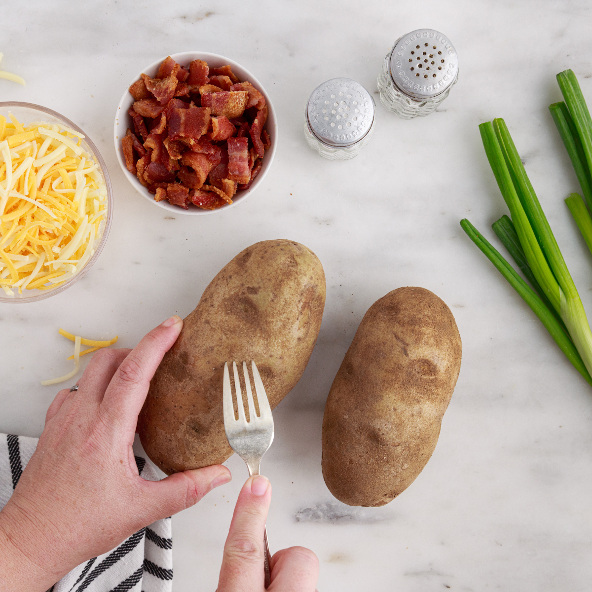 Raw potatoes washed dried and pricked with fork to release steam before air fryer cooking process