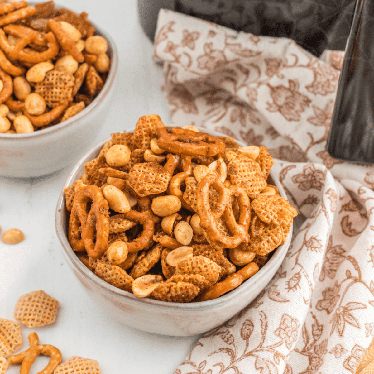 Air fryer Chex Mix in a bowl with crunchy cereal, pretzels, and nuts