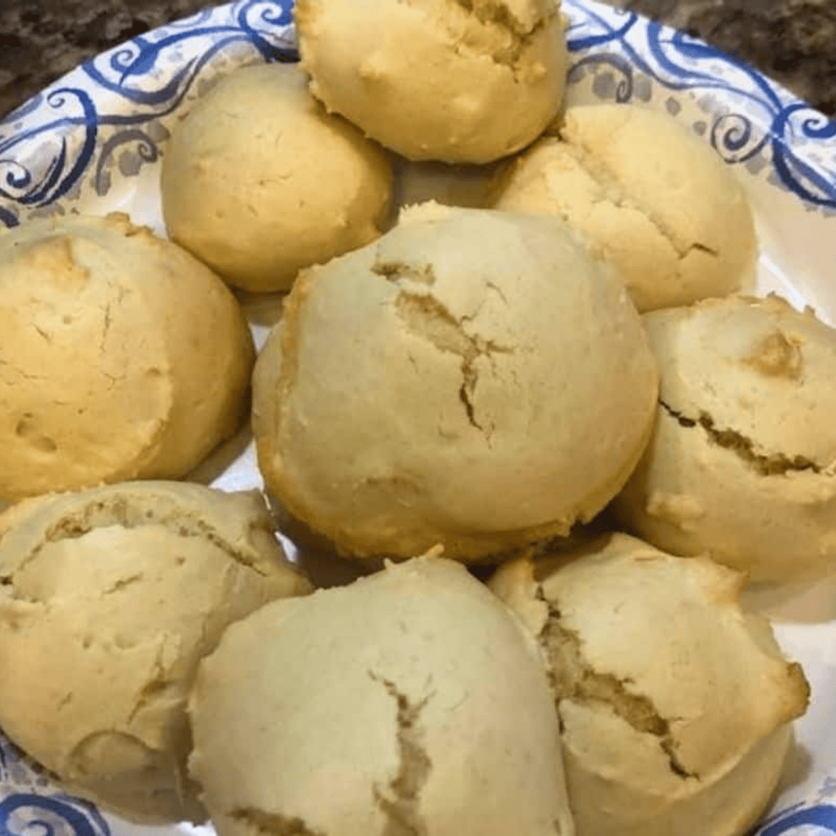 Scooping Italian cookie dough onto parchment-lined air fryer basket, cooking at 320°F for 3 minutes.