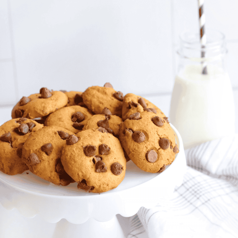 Two tablespoons of peanut butter chocolate chip cookie dough in an air fryer basket lined with parchment paper.