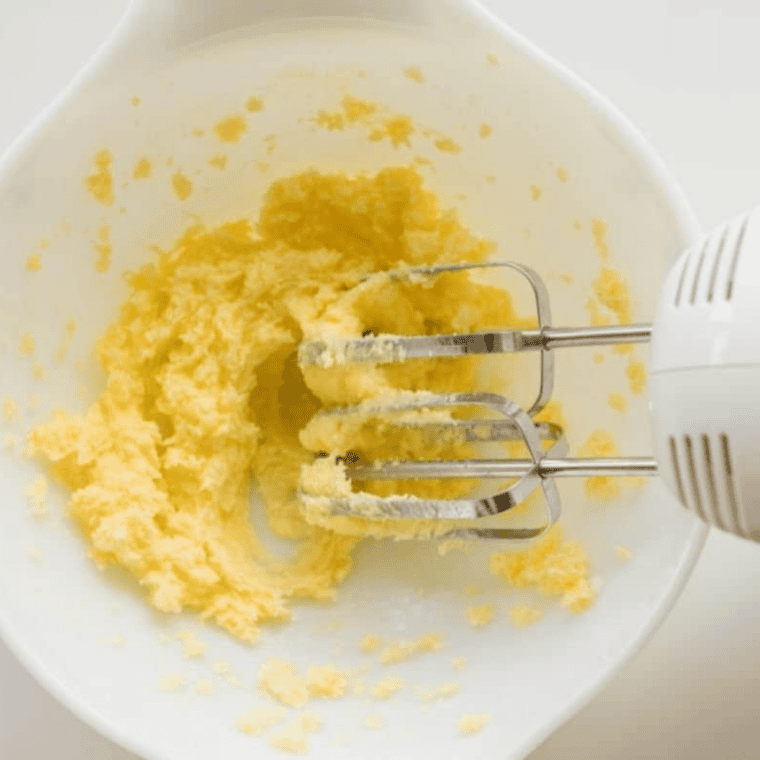 Begin by beating the butter and sugar together in a large bowl until creamy.