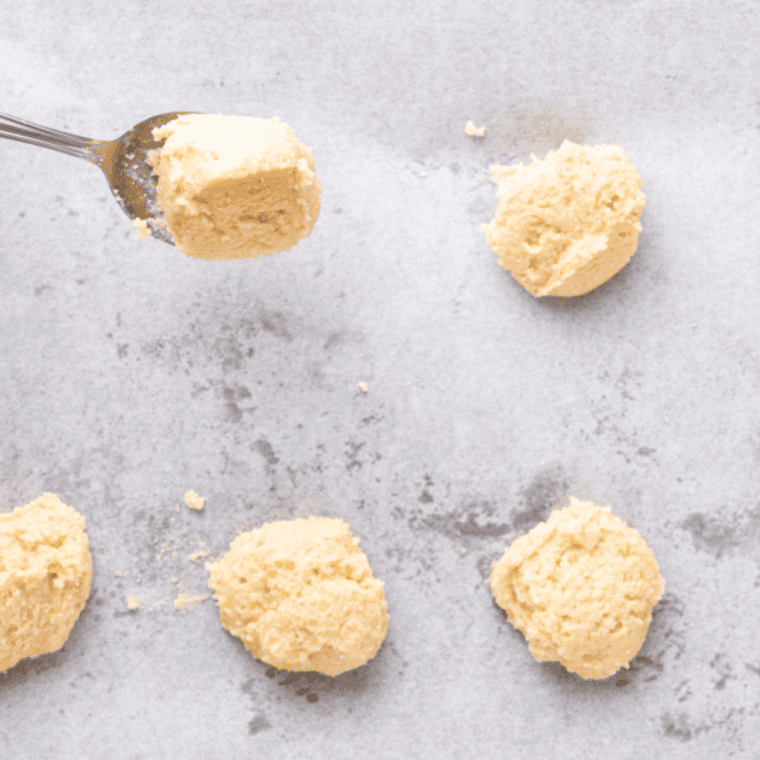 Snickerdoodle cookie dough arranged on a greased air fryer tray, ready to bake at 340°F.