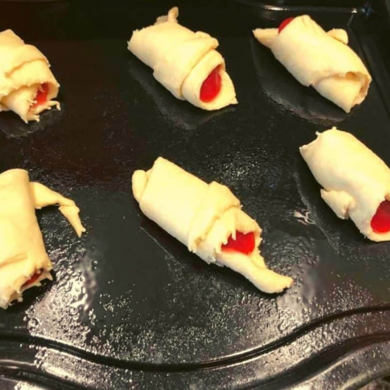 Air fryer basket lightly greased and lined with parchment paper, crescent rolls arranged in a single layer with space between each for even cooking and rising