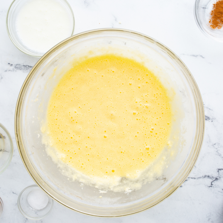Lemon cake batter in a mixing bowl with lemon zest