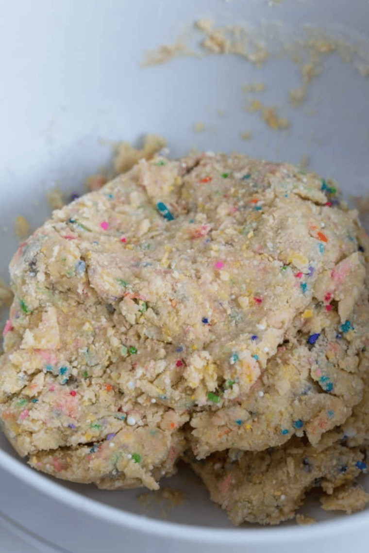 Shaping cookie dough into rounds, dipping into sprinkles, and placing on air fryer tray.