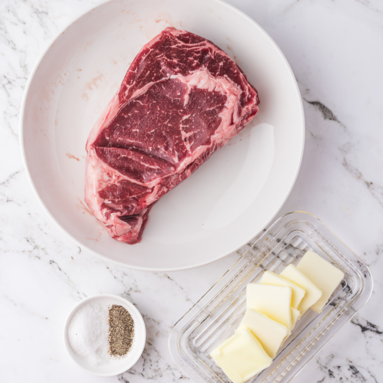 Ninja Crispi steak ingredients: raw ribeye, avocado oil, kosher salt, pepper, garlic, butter, and parsley