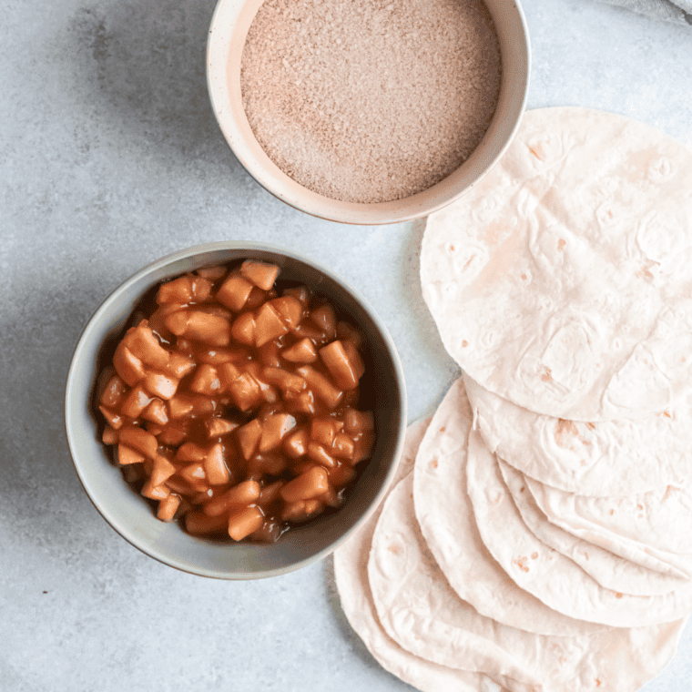 Flour tortilla laid flat on a cutting board before filling