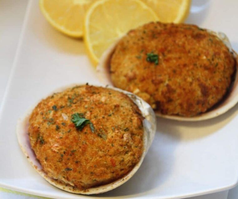 Baked stuffed clams (quahogs) topped with parsley and served with lemon