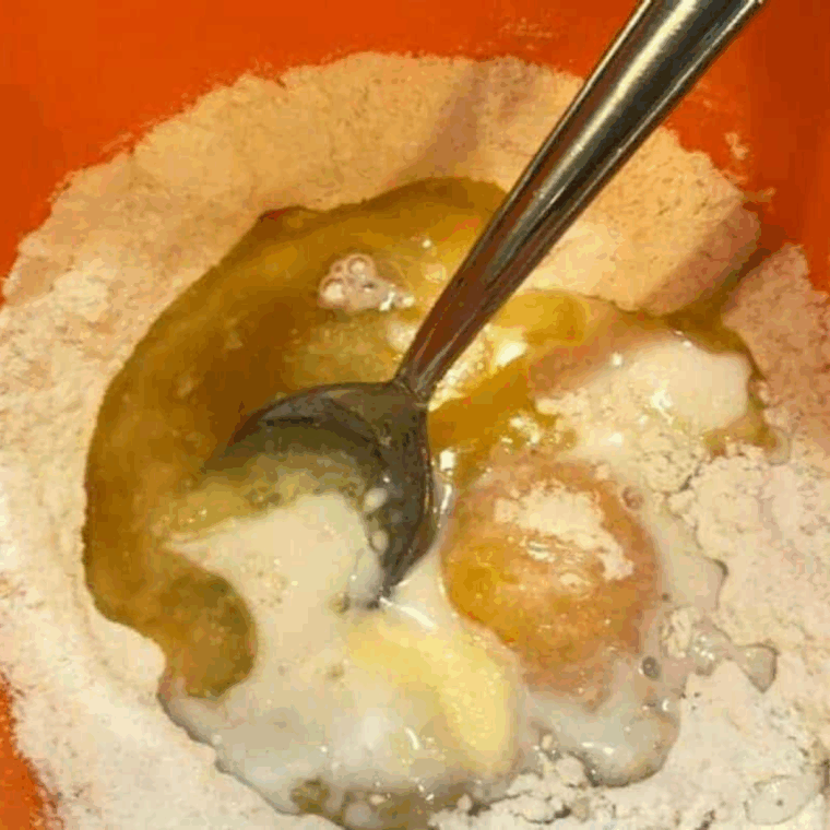 Mixing flour, baking powder, salt, melted butter, sugar, egg, vanilla, and milk into smooth blueberry muffin batter