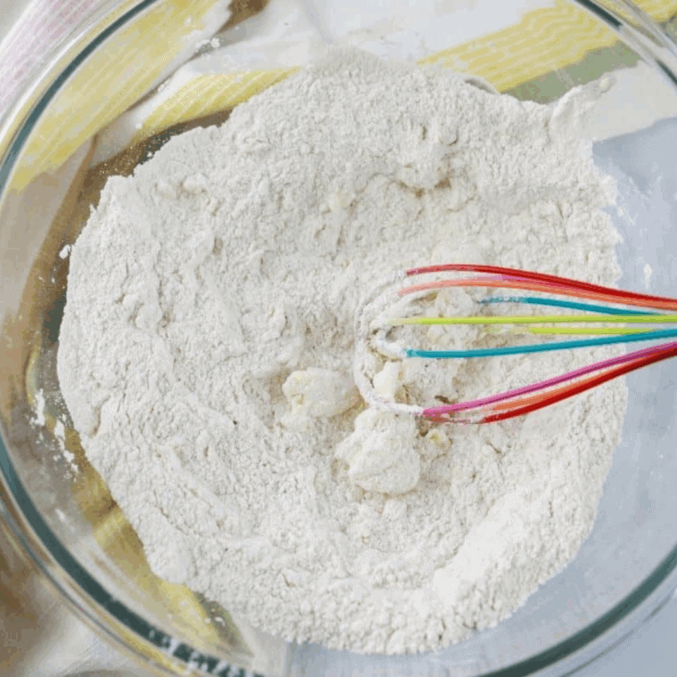 Mixing dry and wet ingredients together in a small bowl to make muffin batter