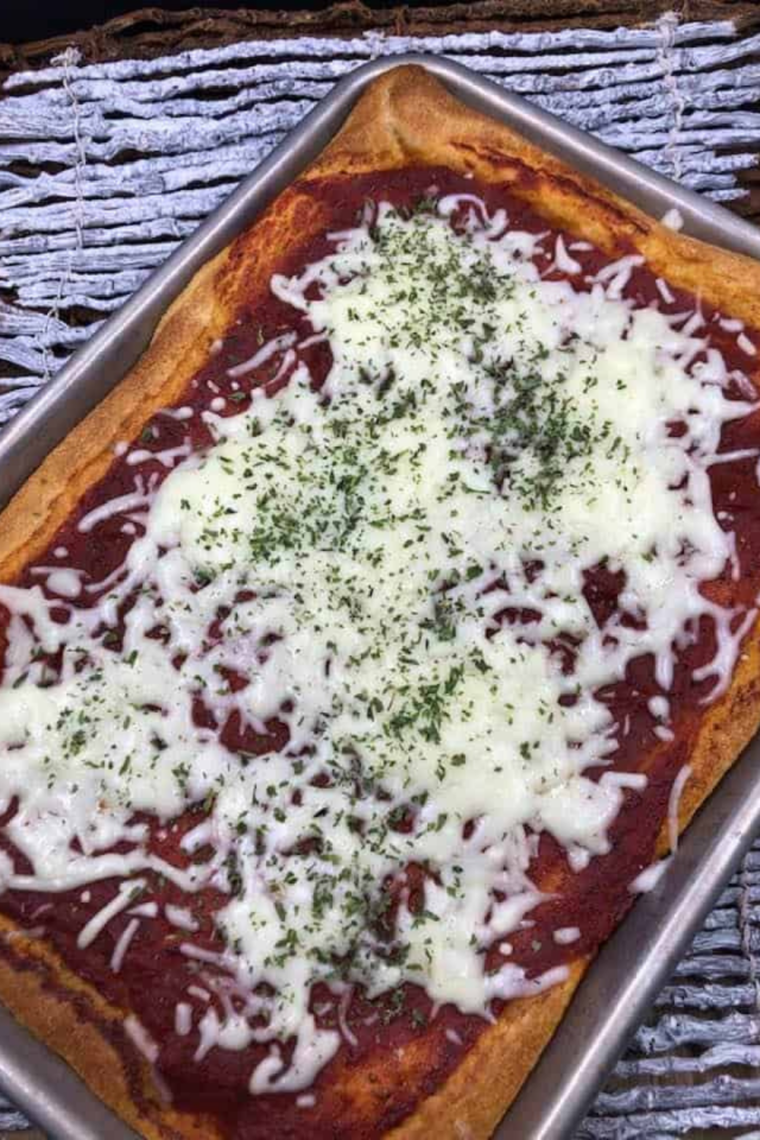 Finished air fryer sheet pan pizza with bubbling golden cheese, fresh out of the air fryer