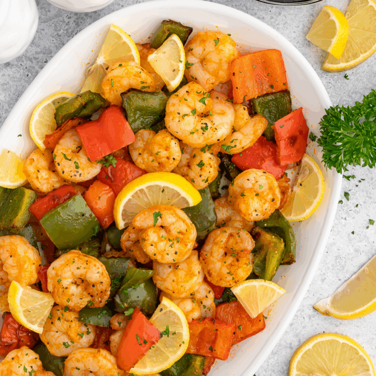 Colorful shrimp stir fry with bell peppers, broccoli, and carrots, cooked in an air fryer and served in a bowl.