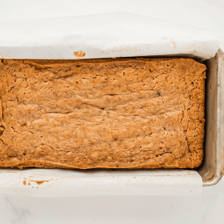 Loaf of Easy Banana Bread made with shortening, showing soft, moist texture and golden-brown crust on a plate.