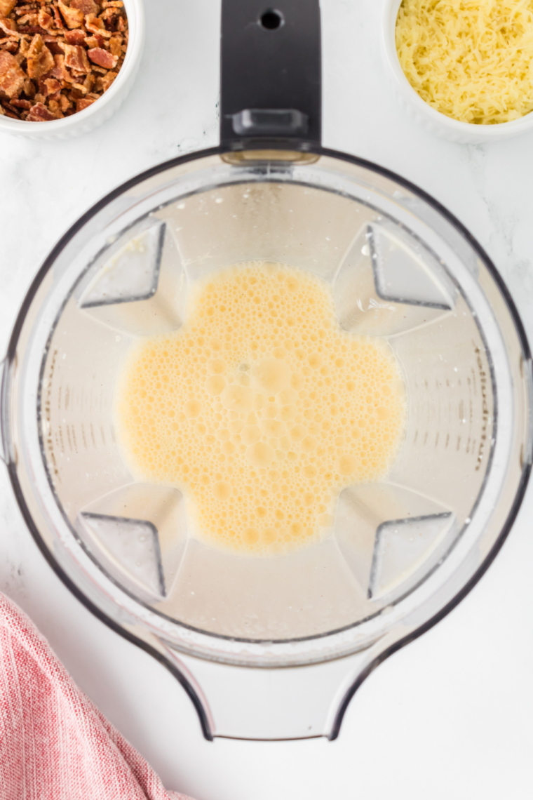 Whisking eggs, heavy cream, truffle oil, salt, and pepper in a bowl until smooth