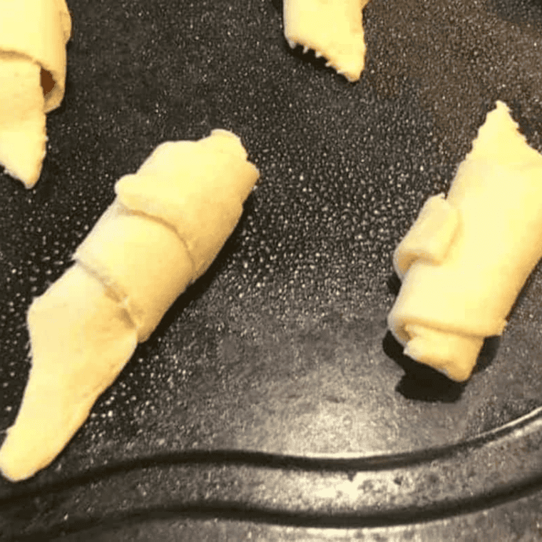 Filled crescent rolls rolled up and ready for the air fryer basket