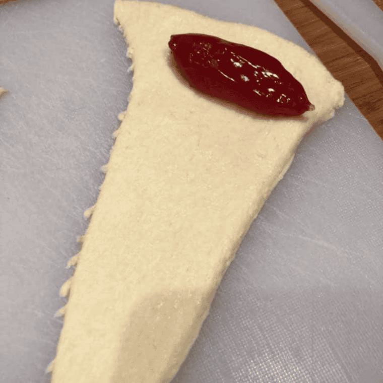 Cherry pie filling spooned onto the wide end of a crescent dough triangle