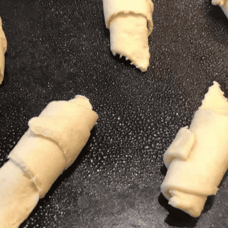 Rolled cherry crescents arranged in an air fryer basket before cooking