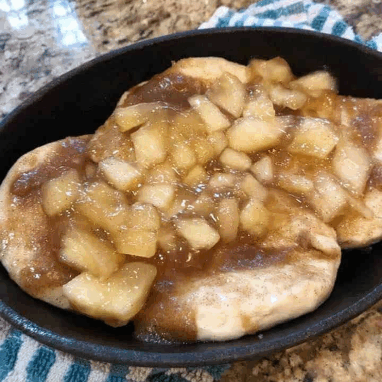 Apple pie filling being spooned into the center of biscuit dough