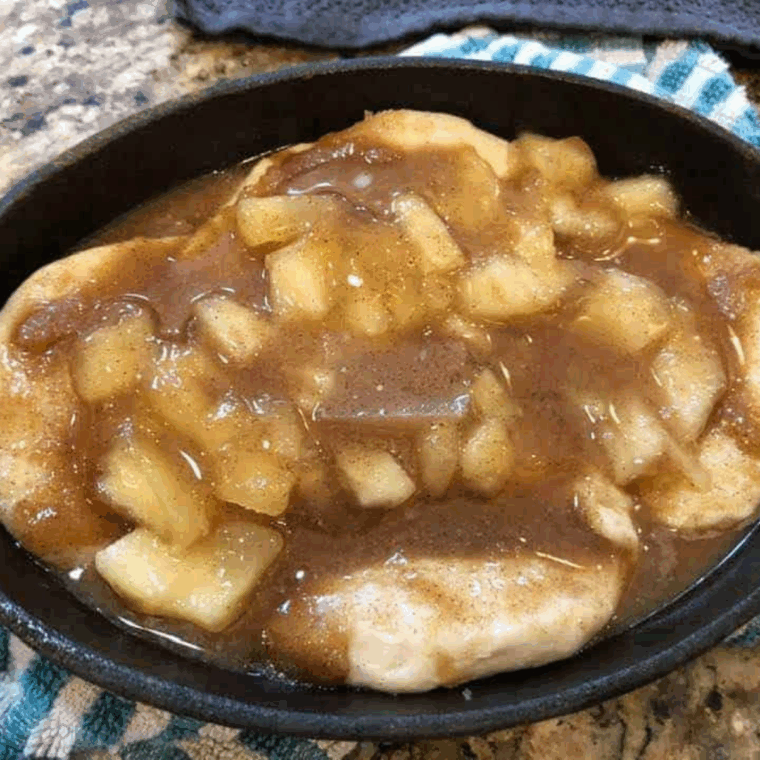 Remaining butter, cinnamon, and sugar mixture poured over apple-filled biscuits, ready to cook in air fryer at 320&deg;F