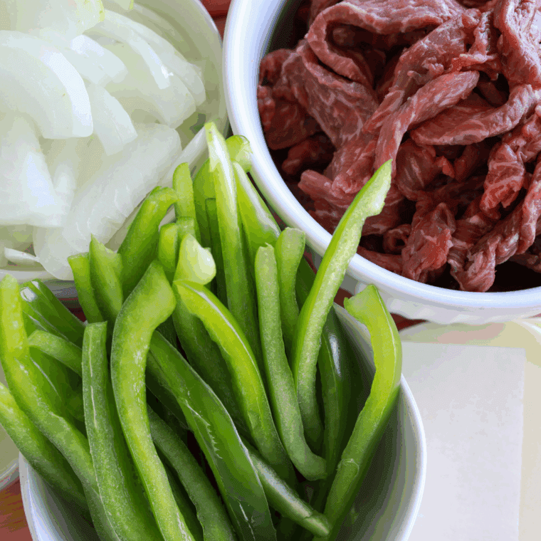 Ingredients needed for Easy Ninja Foodi Philly Cheesesteaks on kitchen table.