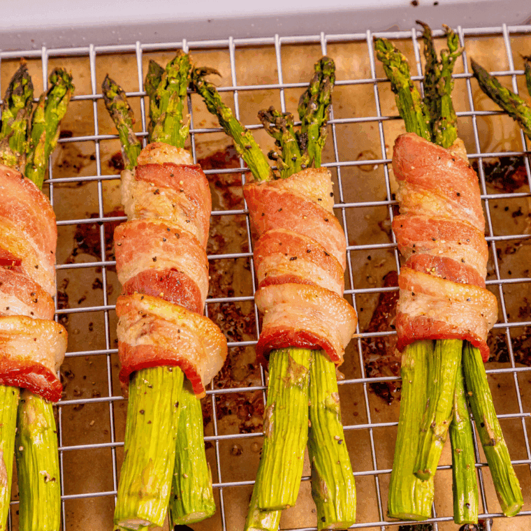 Crispy air fryer bacon wrapped asparagus bundles served on a plate.