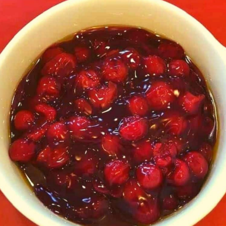 Lightly greased air-fryer-safe baking dish with cherry pie filling spread evenly across the bottom, ready for crumble topping.