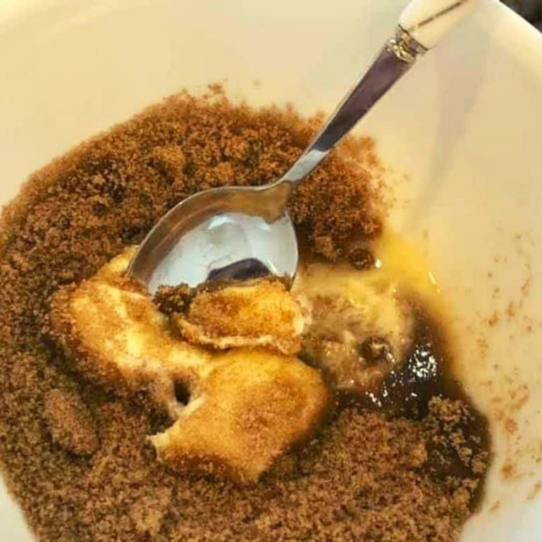 Bowl of oats, brown sugar, flour, cinnamon, and salt being mixed with cold butter to create a crumbly streusel topping.
