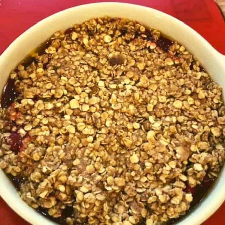 Cherry filling covered with an even layer of golden oat crumble before air frying.
