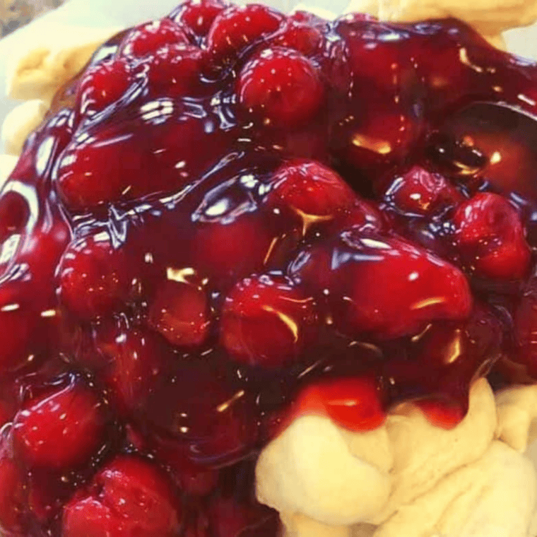 Cherry pie filling and biscuit pieces tossed together in a mixing bowl