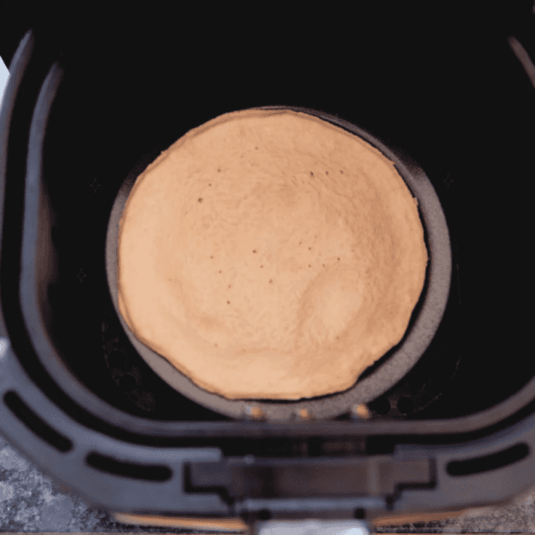 Blind-baked golden pie crust for air fryer pumpkin pie resting in the basket