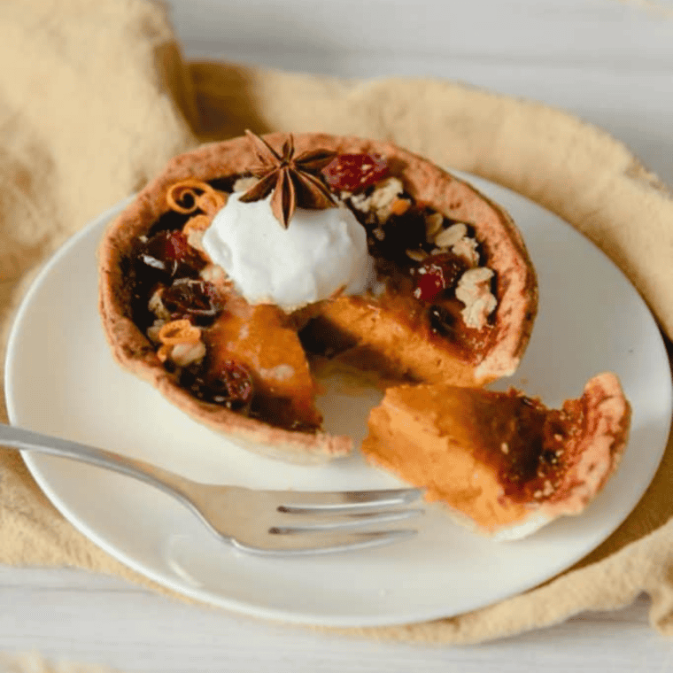 Air fryer pumpkin pie with a flaky crust and creamy spiced filling, topped with whipped cream
