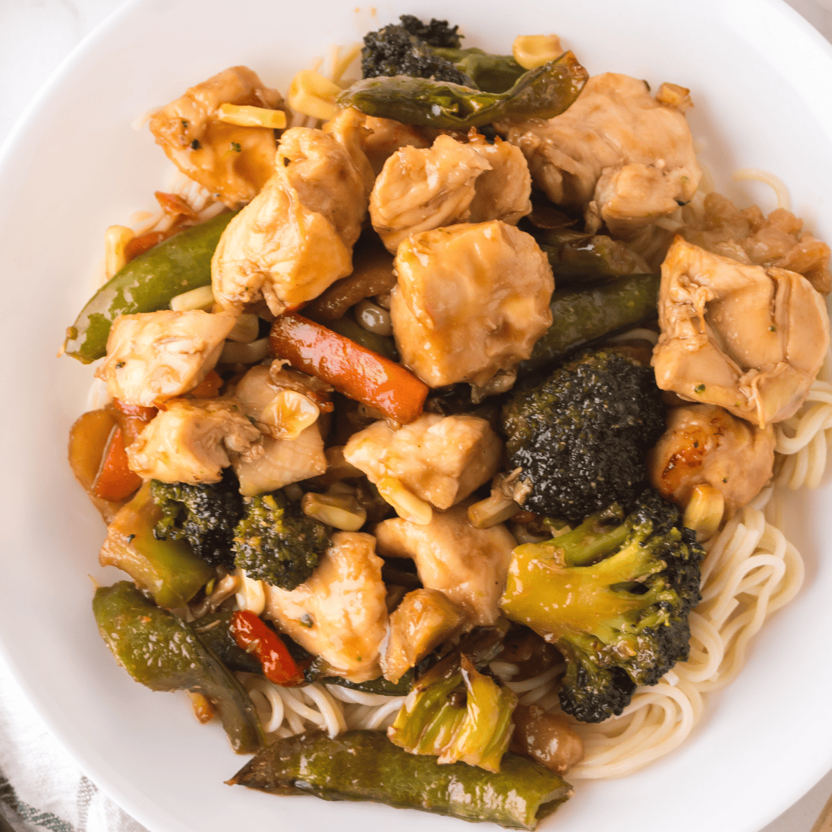Ninja Foodi chicken stir fry with colorful bell peppers, broccoli, and carrots served in a bowl.