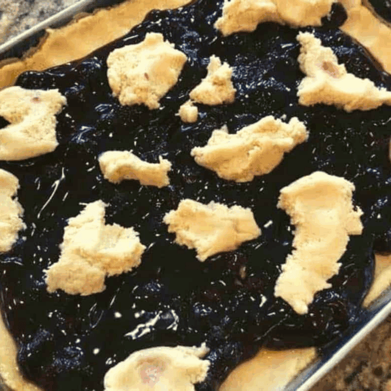 Add the scattered dough on top of the blueberry pie filling.