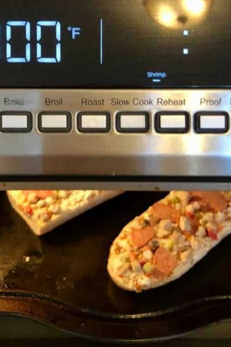 Frozen French bread pizza arranged in air fryer basket in single layer