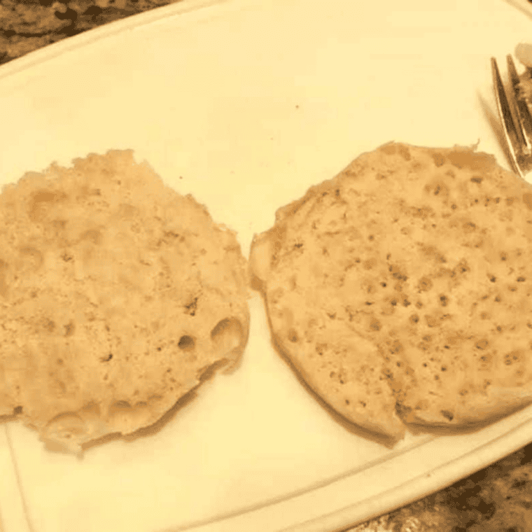 Separating English muffins into halves with a fork before topping.