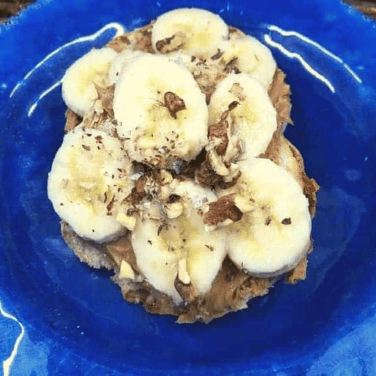 Toasted English muffins topped with peanut butter, banana slices, and crushed nuts, fresh from the air fryer.