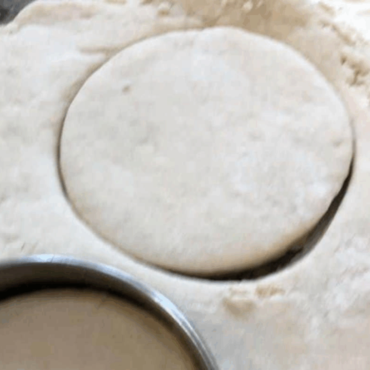 Mixing Bisquick and milk, rolling dough, and cutting biscuits.
