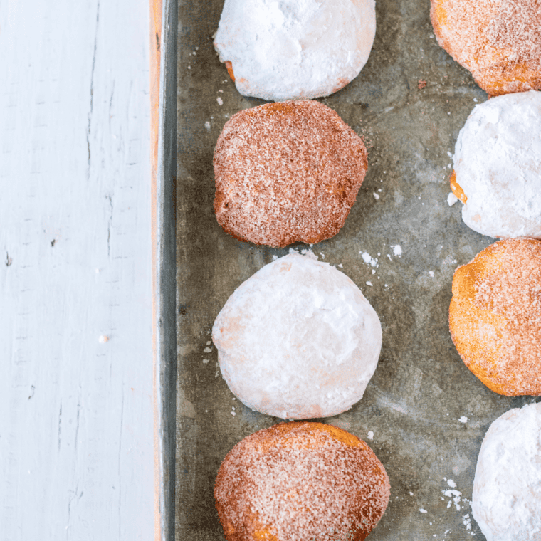 Air fryer churro donut holes coated in cinnamon sugar on serving plate