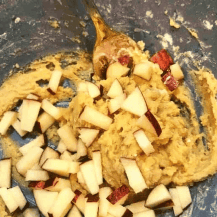 Mixing flour, baking powder, cinnamon, sugar, salt, egg, melted butter, vanilla, cream, and diced apples in a bowl until well combined.