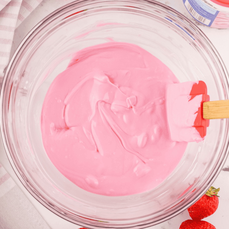 Mixing strawberry cake mix with eggs vegetable oil and chocolate chips in a bowl.