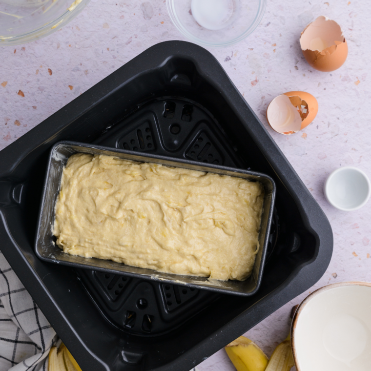 Air fryer with pound cake inside, baking at 320&deg;F, checking doneness with toothpick