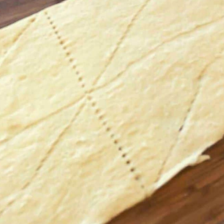 Crescent roll dough, melted butter, minced garlic, and Italian seasoning on a counter