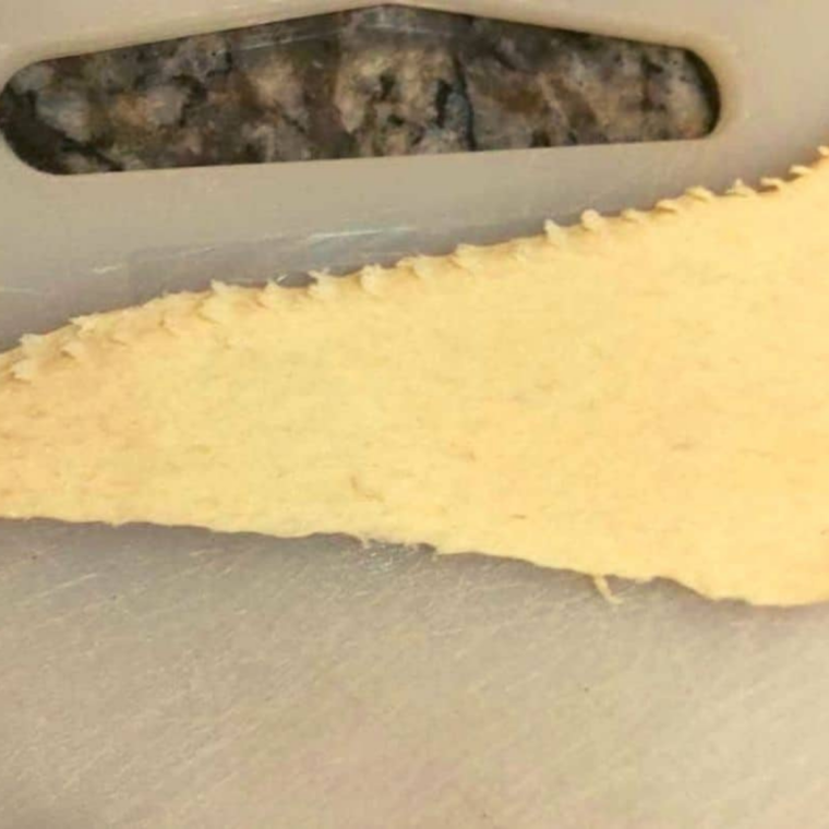 Crescent roll dough unrolled and separated into eight triangles on a flat surface