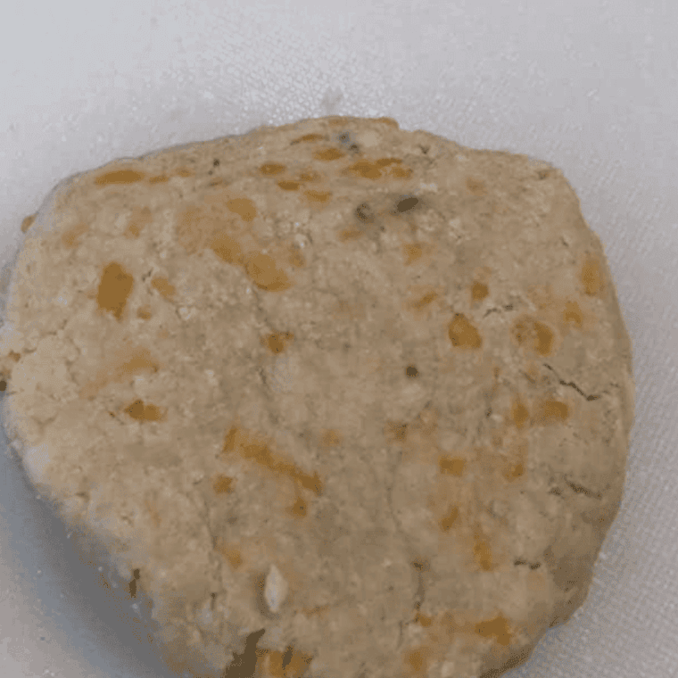 Kneading biscuit dough, placing in air fryer, and baking until golden.