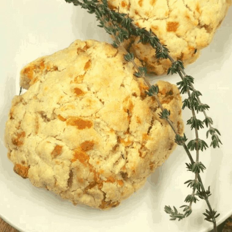 Air fryer cheddar thyme flaky biscuits with golden crust and melted cheese.