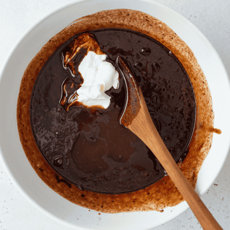 Bundt pan filled with chocolate cake batter placed in air fryer cooking at 320&deg;F until toothpick comes out clean