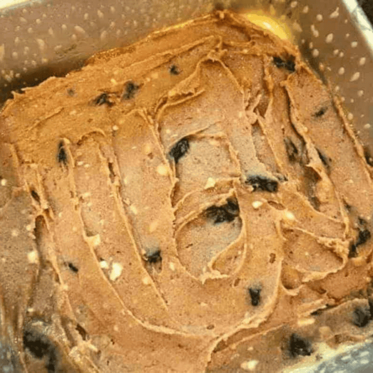 Apple butter bar batter spread in a baking pan inside an air fryer basket
