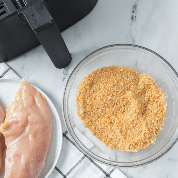 Ingredients for air fryer artichoke chicken: chicken breasts, panko, mayonnaise, artichoke hearts, tomatoes, and cheese