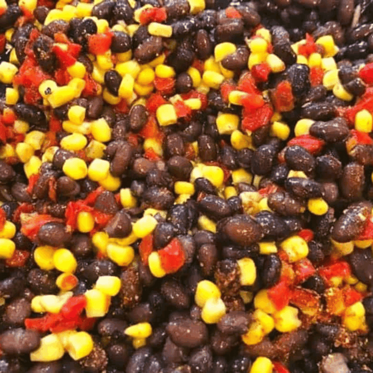 Black beans, corn, and diced red peppers sautéing with southwestern spice in a skillet