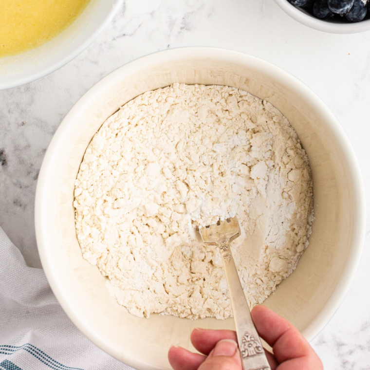 Flour, baking powder, and salt mixed into blueberry pound cake batter